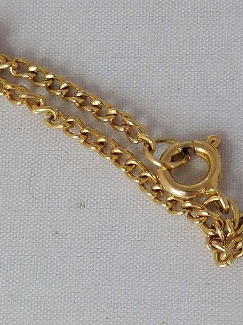 AN UNUSUAL CAGED TIGERS EYE PENDANT ON A GOLD TONE CHAIN