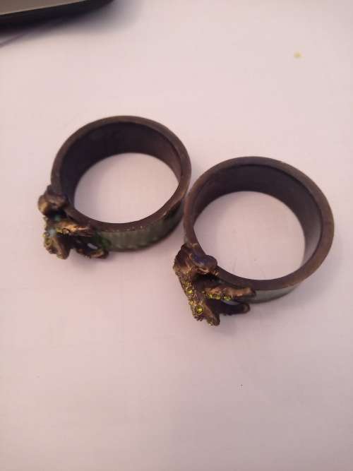 A PAIR OF ENAMEL NAPKIN RINGS MODELLED WITH A FROG ENCRUSTED WITH GREEN CRYSTALS