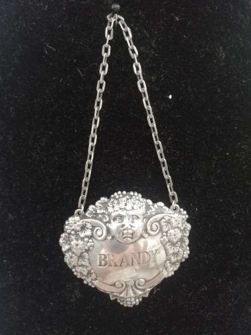 A HALLMARKED SILVER BRANDY DECANTER LABEL