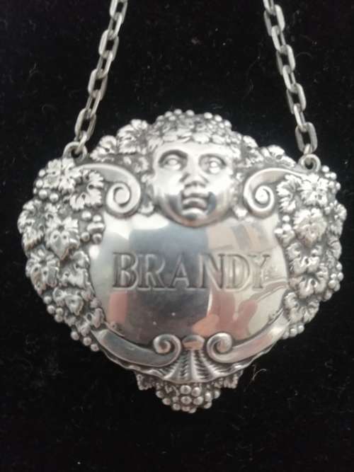 A HALLMARKED SILVER BRANDY DECANTER LABEL