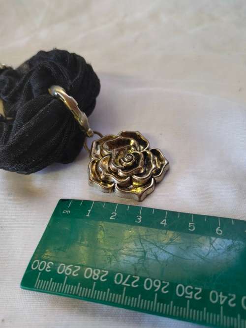 A stunning black scarf necklace with big rose pendant