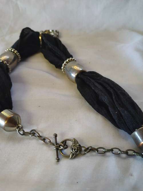 A stunning black scarf necklace with big rose pendant