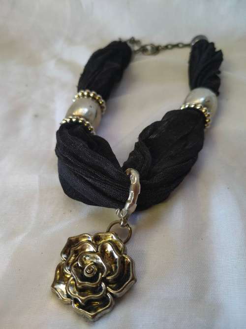 A stunning black scarf necklace with big rose pendant