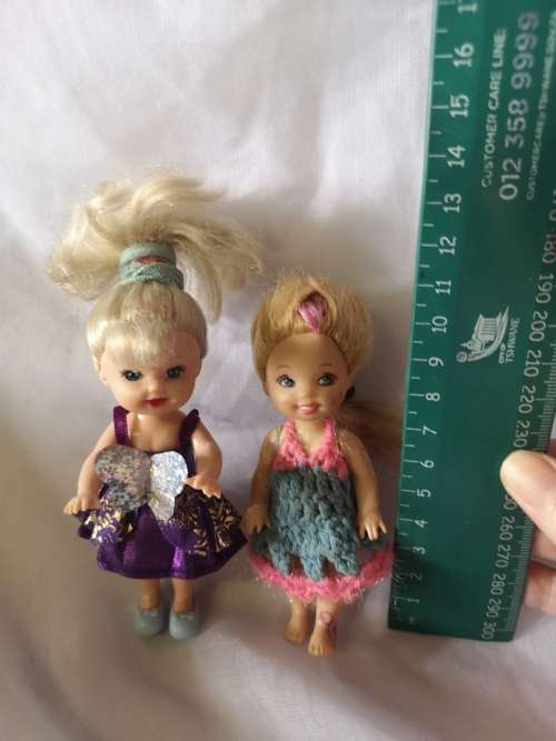 Two small Barbie's sister-like dolls with toy furniture.