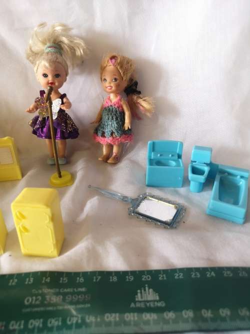 Two small Barbie's sister-like dolls with toy furniture.