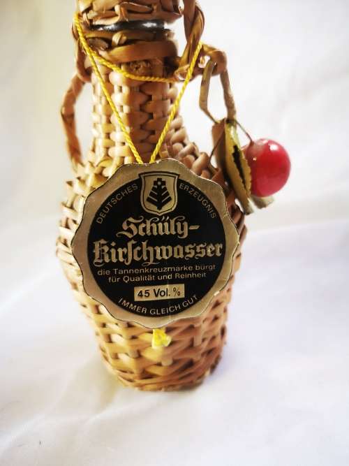 A small bottle of liquor in a beautiful woven basket - still sealed