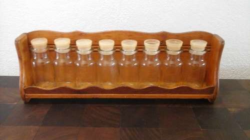 A LIGHT VINTAGE CARVED WOODEN SPICE RACK. BOTTLE IS MARKED BOTTLE MADE IN TAIWAN!
