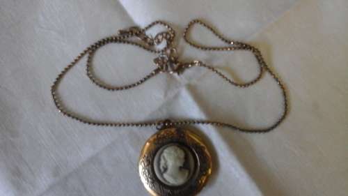 A VINTAGE LOOKING BRASS COLOURED CAMEO LOCKET ON A CHAIN. BEAUTIFUL PIECE