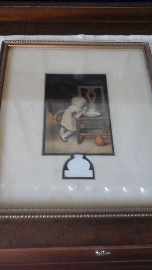 CUTE PICTURE OF A VICTORIAN CHILD IN A KITCHEN EATING BREAKFAST.