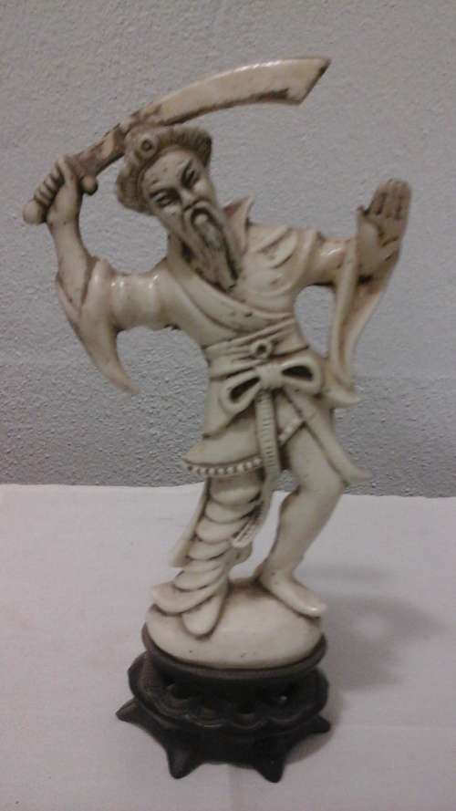 A VINTAGE LOOKING STATUE OF AN ORIENTAL SWORD FIGHTER. NOT SURE WHAT ITS MADE FROM. EXTREMELY LIGHT