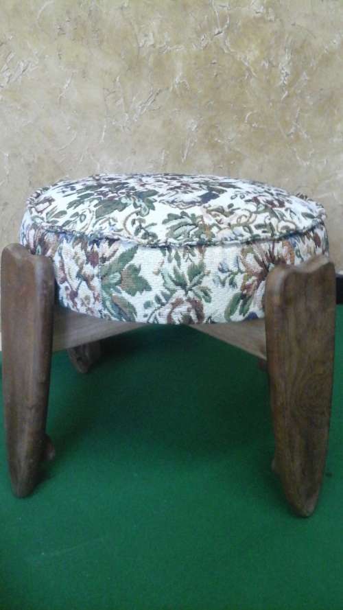 AN EXTREMELY UNUSUAL VINTAGE FOUR LEGGED ROUND OTTOMAN/FOOTSTOOL.COVERED IN TAPESTRY STYLE FABRIC