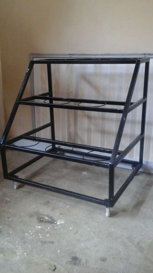 PHENOMENAL STEEL FLOWER STAND ON WHEELS. HOLDS EIGHT BUCKETS. AWESOME AND USEFUL PIECE!