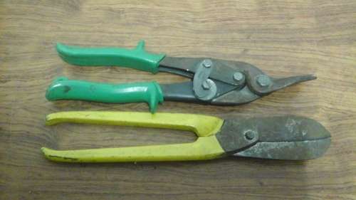 TWO PRACTICAL DIFFERENT STYLE TIN SNIPS. ONE HAS A PLASTIC COVERING OVER THE STEEL