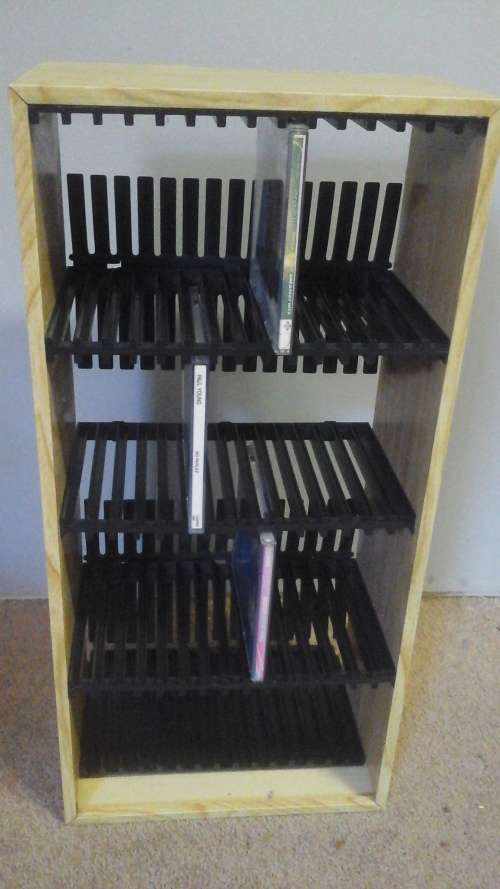 A FANTASTIC WOODEN TYPE CD RACK THAT TAKES 60 CD'S. HAS PLASTIC INSERTS THAT HOLD THE CD'S IN PLACE
