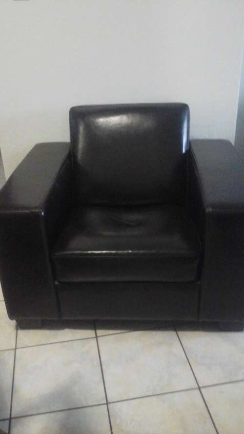 A COMFORTABLE BROWN FAUX LEATHER BOXED SHAPED SINGLE SEATER COUCH. BACK IS ROUNDED FOR COMFORT