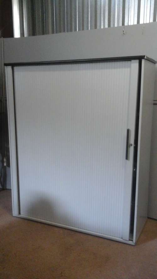 A LARGE USEFUL FILING CABINET. HAS HANGING RACKS AND SHELVES. THE DOOR IS A ROLLER SHUTTER DOOR