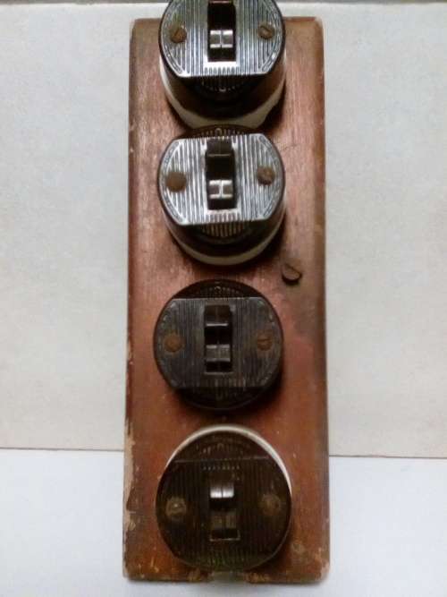 FOUR VINTAGE PORCELAIN LIGHT SWITCHES MOUNTED ON SOLID WOOD BRACKET