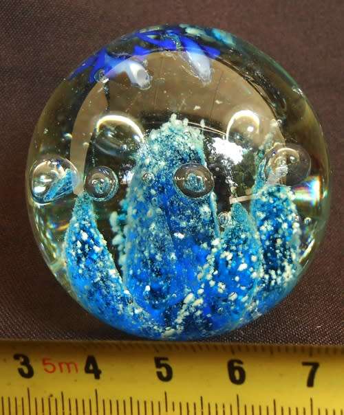 glass paperweight with blue fishes swimming over blue coral