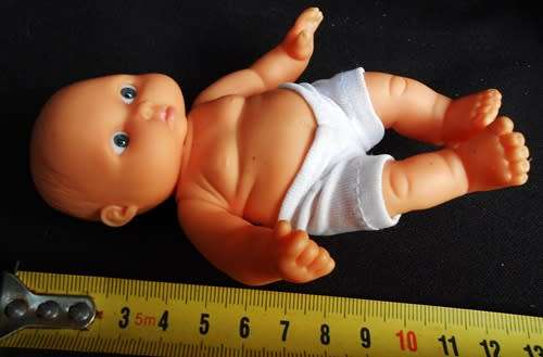 Small chubby baby doll looks like Berenguer doll with pouting face and blue eyes