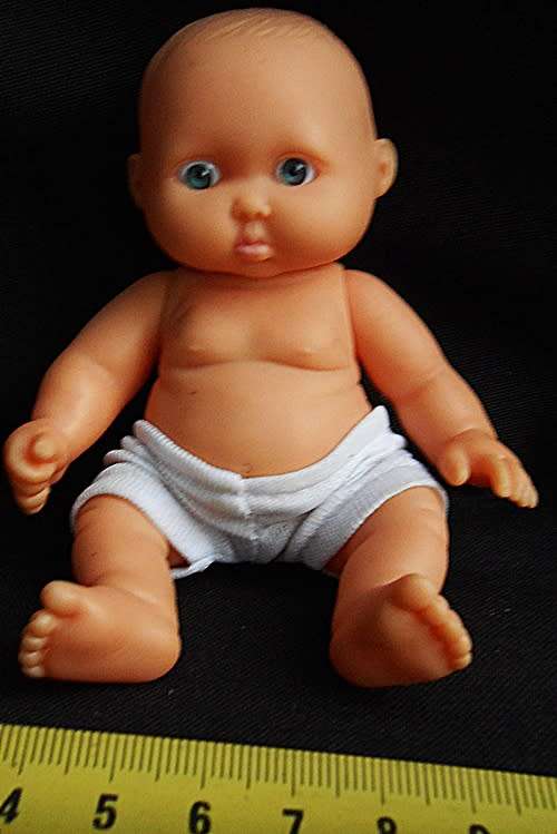 Small chubby baby doll looks like Berenguer doll with pouting face and blue eyes