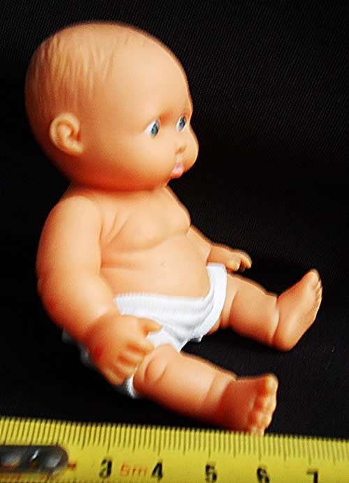 Small chubby baby doll looks like Berenguer doll with pouting face and blue eyes