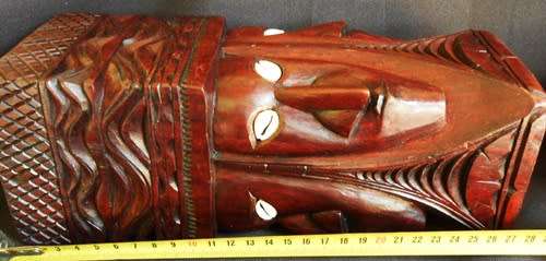 well made wooden statue in hard wood carved with heads with cowrie shell eyes