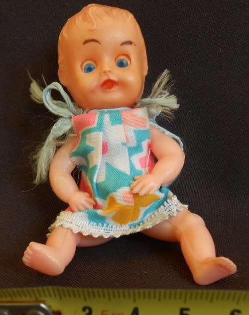 Vintage small hard plastic doll in original dress made in hong kong