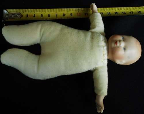 Collectable small porcelain baby doll in nightdress