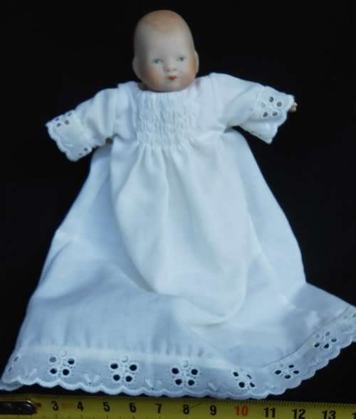 Collectable small porcelain baby doll in nightdress