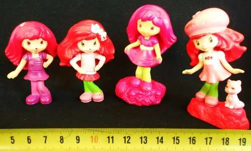 four collectible Strawberry Shortcake figures
