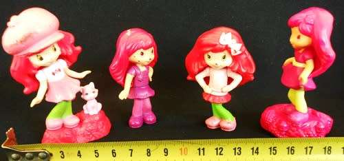 four collectible Strawberry Shortcake figures