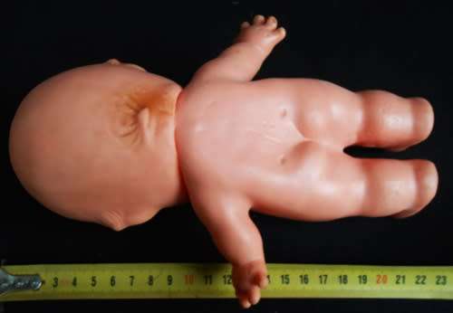 collectible small Kewpie doll with blue eyes and blunt fingers