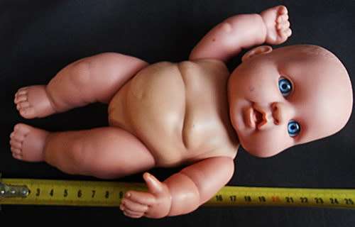 Chubby Baby Girl Doll anatomically correct in pink knitted dress.