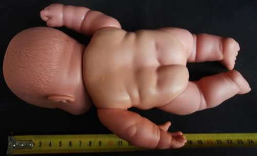 Chubby Baby Girl Doll anatomically correct in pink knitted dress.