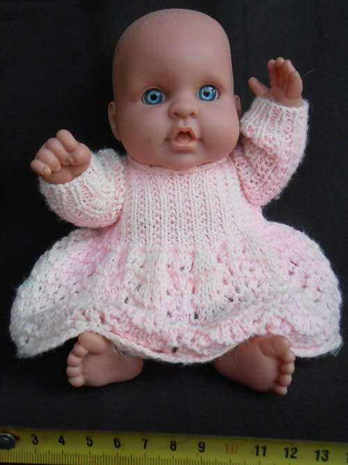 Chubby Baby Girl Doll anatomically correct in pink knitted dress.