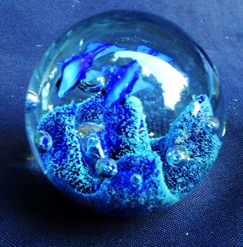 collectable glass paperweight with  blue fish swimming over blue coral