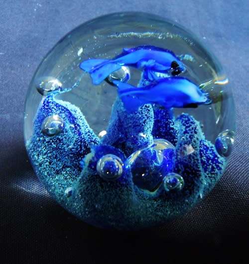 collectable glass paperweight with  blue fish swimming over blue coral