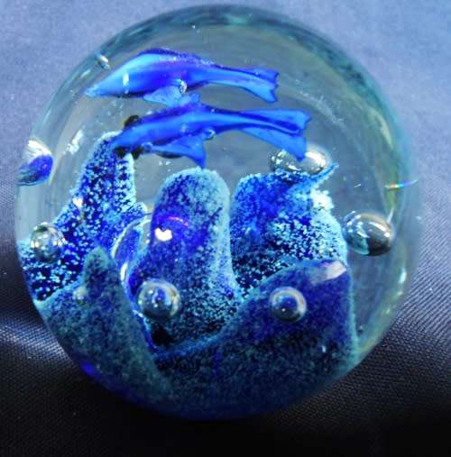 collectable glass paperweight with  blue fish swimming over blue coral
