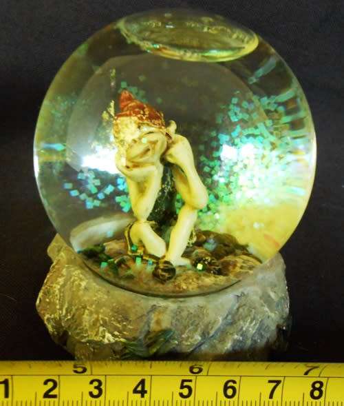 glass glitterball with fairy figure on resin base.