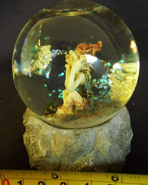 glass glitterball with fairy figure on resin base.