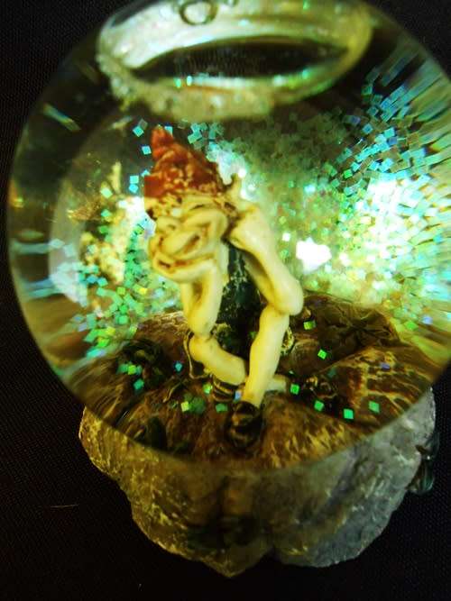 glass glitterball with fairy figure on resin base.