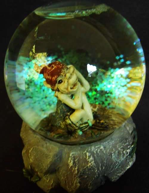 glass glitterball with fairy figure on resin base.