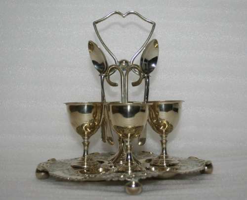 A Marvelous Very ornate silver plated egg cup Cruet stand and spoons.