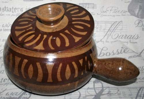 A Large vintage pottery bowl with a lid an explosion of color on both sides and a wonderful handle.