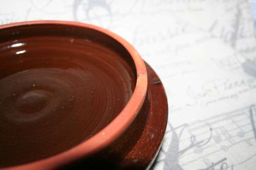 A Large vintage pottery bowl with a lid an explosion of color on both sides and a wonderful handle.