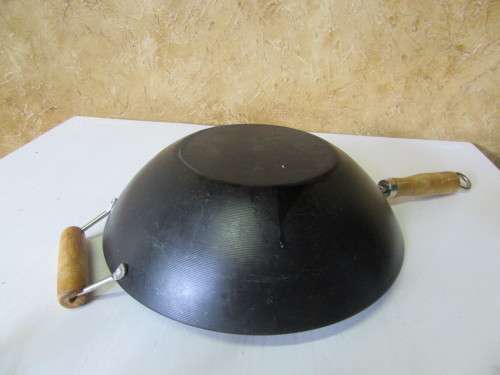 Large vintage steel wok with wooden handle. This is a very large and heavy duty wok.