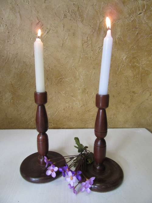 Two antique turned wood candle holder. The slender candlestick holder features a round base bid p/e