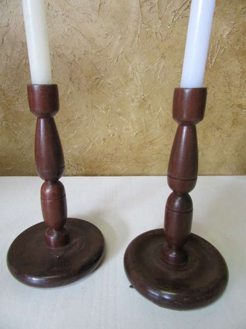 Two antique turned wood candle holder. The slender candlestick holder features a round base bid p/e