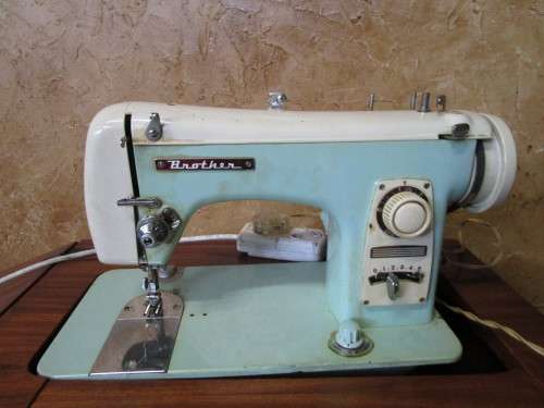 A VINTAGE BROTHER SEWING MACHINE IN A CUPBOARD IN WORKING CONDITION
