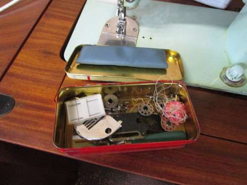 A VINTAGE BROTHER SEWING MACHINE IN A CUPBOARD IN WORKING CONDITION